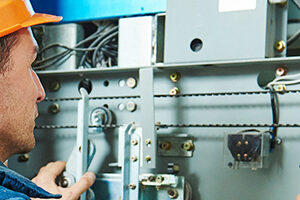 Electrician works with elevator lift equipment